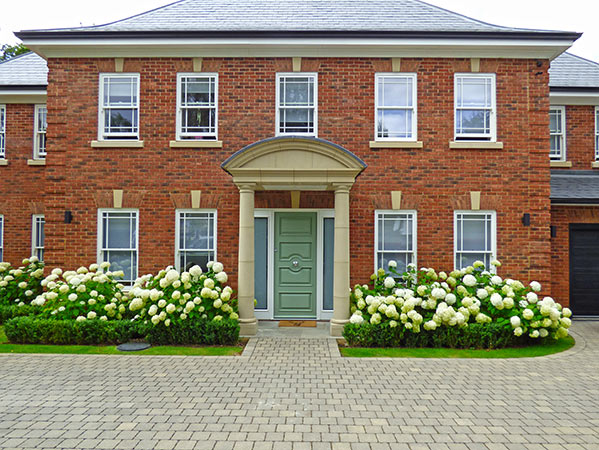 Regency style house with hydrangeas planted in-front to complement and soften the visual approach